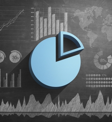 light blue pie graph on top of chalkboard background with other graphs and charts.