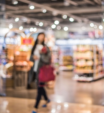 woman carrying bags walking through grocery store
