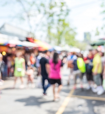 slightly out of focus crowd of consumers shopping in open air retail center