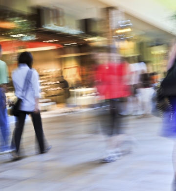 action shot of blurry people walking through retail space